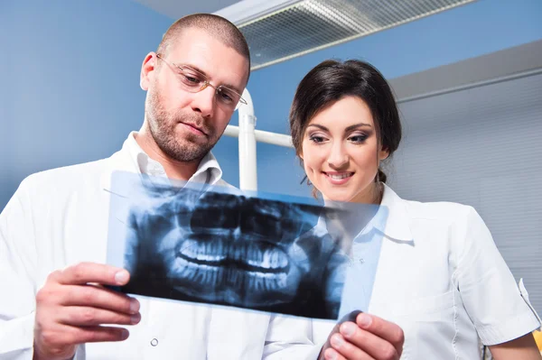 Стоматолог і асистент перевіряють рентген в стоматологічній клініці — стокове фото