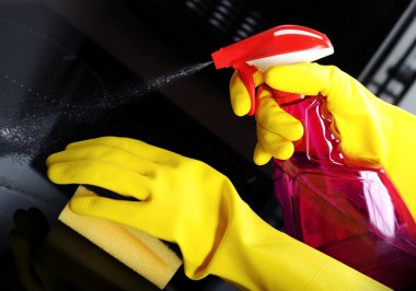 Woman with sponge and rubber gloves cleaning kitchen clipart