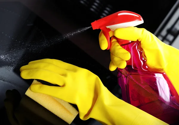 Mujer con esponja y guantes de goma limpieza cocina —  Fotos de Stock