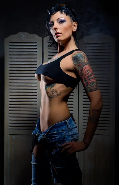 Krásná žena s mnoha tetování představují interiéru — Stock fotografie