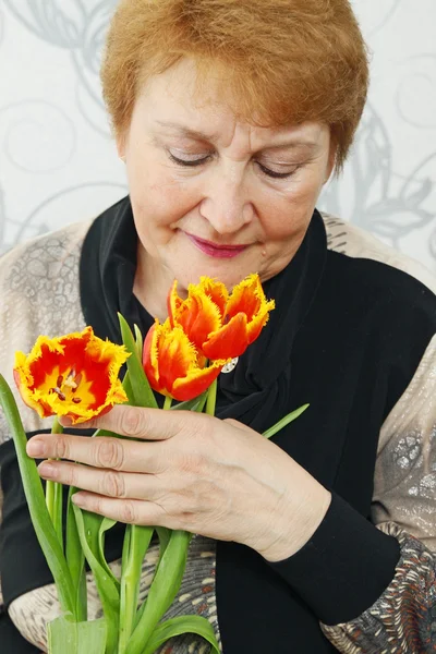Lady att lukta en tulpaner — Stockfoto