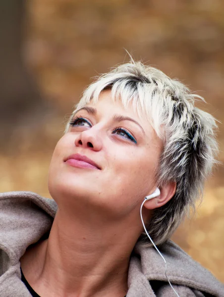 Blond meisje genieten van muziek in de natuur — Stockfoto