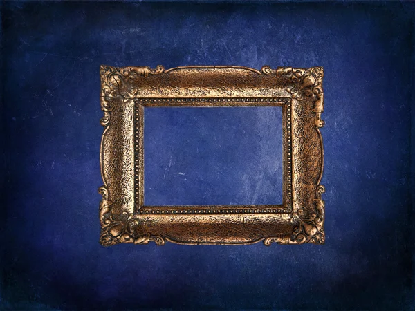 Lege gouden frame op blauwe grunge muur — Stockfoto