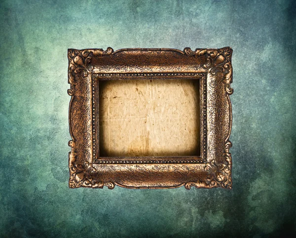 Empty golden frame on grunge light blue wall — Stock Photo, Image