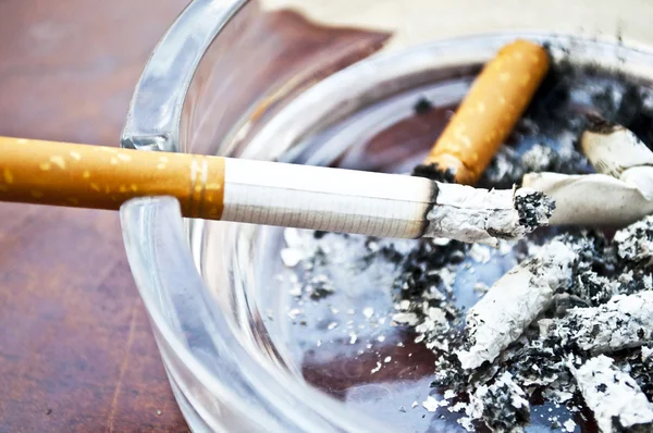 Queima de cigarro em cinzeiro — Fotografia de Stock