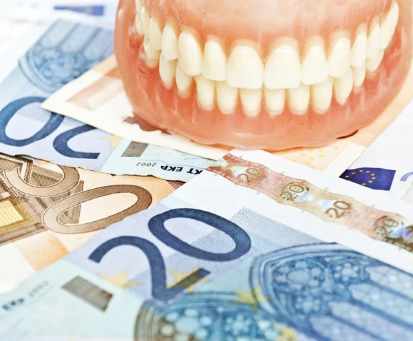 Denture on euros - dental expenses concept — Stock Photo, Image