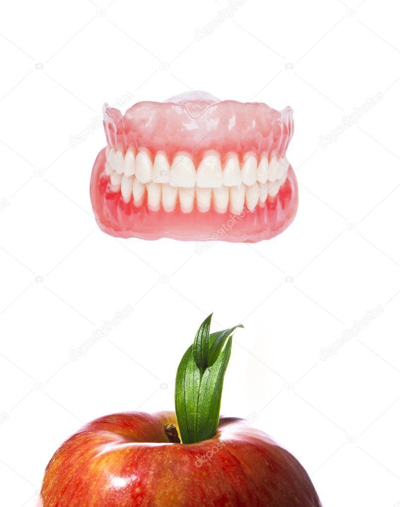 False or fake teeth with red fresh apple - healthy teeth concept
