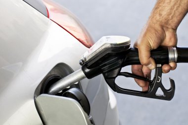 Close-up of a mens hand refilling the car with a gas pump clipart