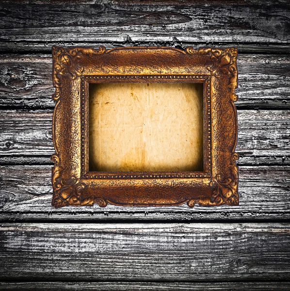 Antique golden frame over wooden wall — Stock Photo, Image