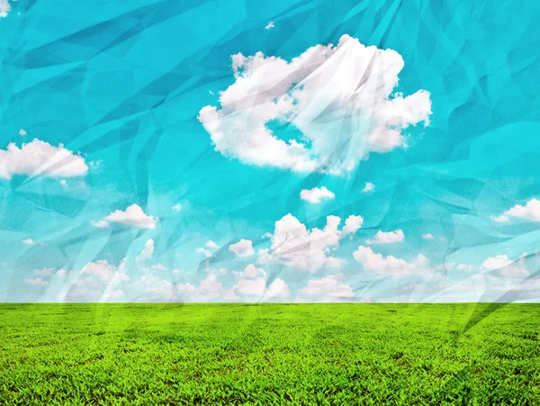 Beautiful green field and blue sky on grunge crumpled paper — Stock Photo, Image