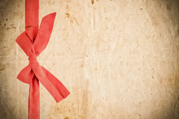 Grunge paper with red bow — Stock Photo, Image