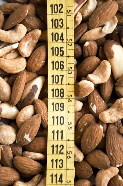 Mixed nuts and measure tape — Stock Photo, Image
