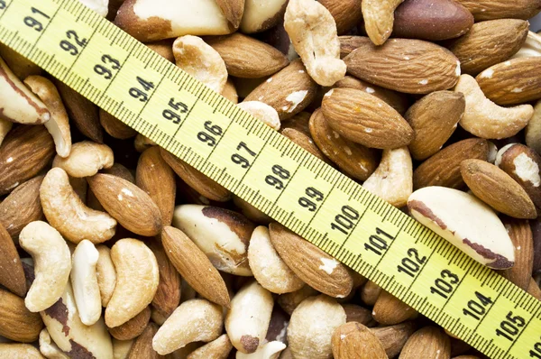Nuts and measure tape — Stock Photo, Image