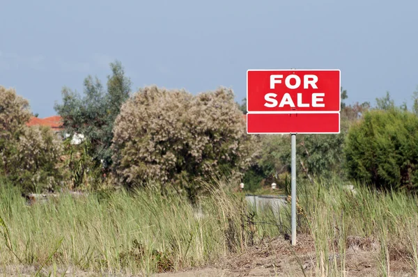 Terreno para venda sinal em campo vazio — Fotografia de Stock
