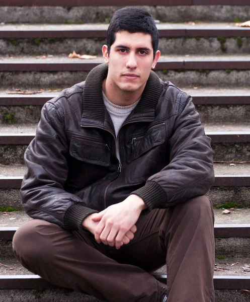 Young handsome man sitting on stairs outside — Stock Photo, Image