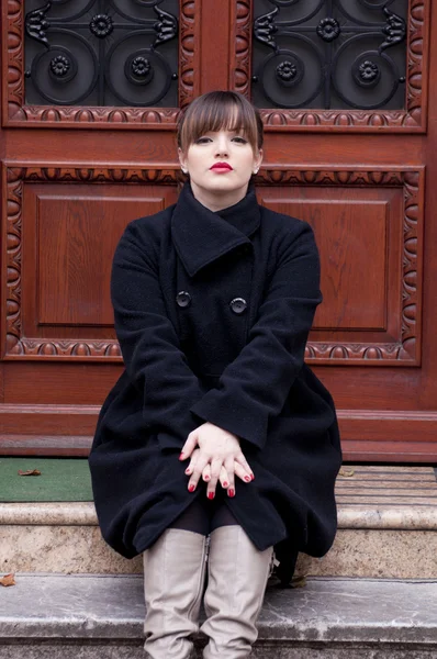 Bella donna seduta davanti alla porta — Foto Stock