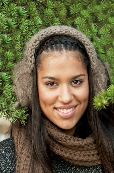 Gyönyörű barna lány ellen karácsonyfa fülvédő — Stock Fotó