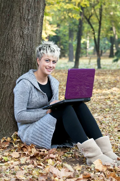 Hermosa mujer joven utilizando el ordenador portátil al aire libre —  Fotos de Stock
