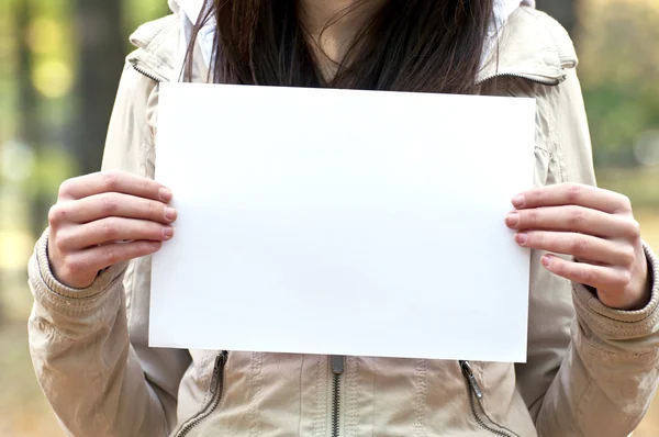 Woman holding empty paper in hands — Stock Photo, Image