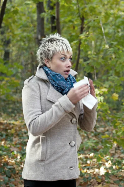 Vértes tüsszögés gyönyörű nő erdőben - allergia-szezon — Stock Fotó