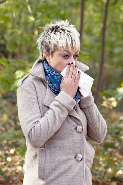 stock image Young woman with tissue blowing her nose
