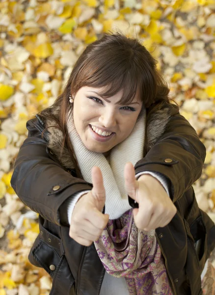 Retrato de cerca de una joven feliz mostrando el pulgar hacia arriba signo de un — Foto de Stock