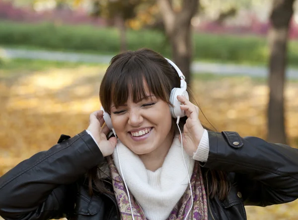 Porträt einer schönen lächelnden Frau, die Musik und Dan hört — Stockfoto