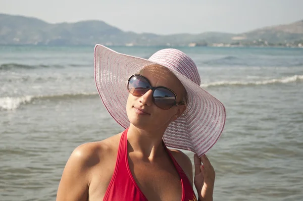 Beautiful woman with straw hat posing near beach — ストック写真