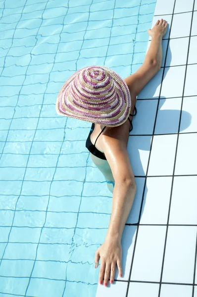Jovem mulher de pé em uma área de piscina — Fotografia de Stock