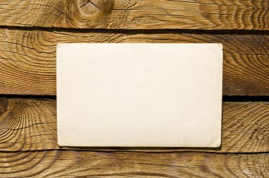 Grunge note paper on wooden background clipart