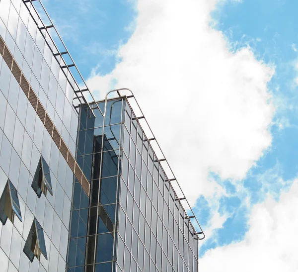 Blå himmel återspeglas i modern byggnad spegel glasväggen — Stockfoto