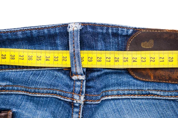 Calça jeans azul e fita métrica isolada - conceito de sobrepeso — Fotografia de Stock