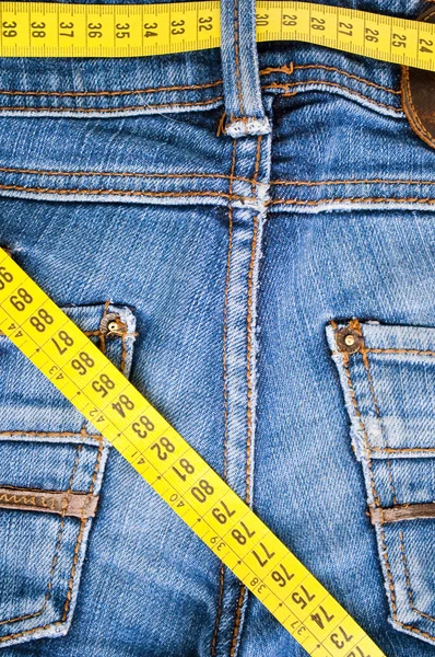 Calça jeans azul e fita métrica - conceito de sobrepeso — Fotografia de Stock