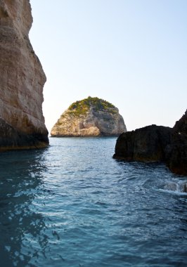 Island in waters of Zakythos island in Greece clipart