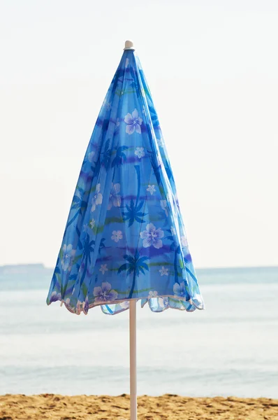Closed blue sunshade parasol on the beach — Stock Photo, Image