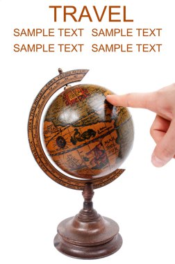 Hand pointing to antique globe - Travel concept clipart