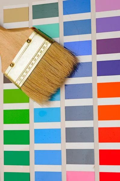 Palette of color samples with paintbrush on white background — Stock Photo, Image