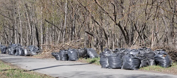 Een stapel van zwarte kunststof vuilniszakken met tonnen afval — Stockfoto