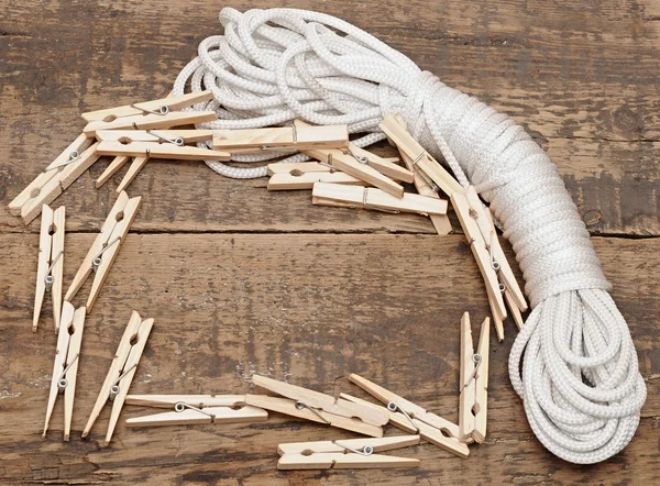 Pinzas de ropa en la cuerda sobre fondo de madera — Foto de Stock