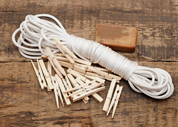 Soap, clothespins and rope on rustic table — Stock Photo, Image