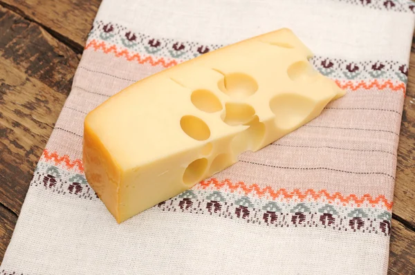 Tahta masada bir parça peynir. — Stok fotoğraf
