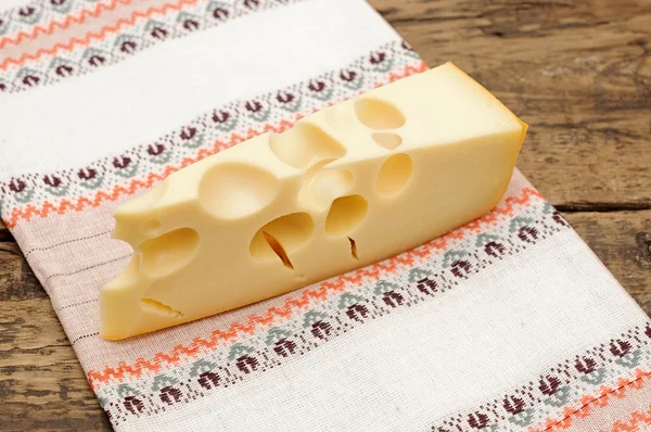 Stukje kaas op een houten tafel — Stockfoto