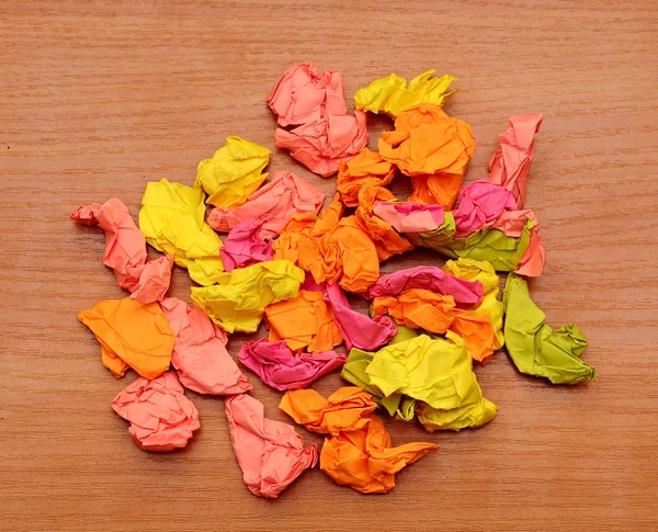 Coleção de papéis amassados coloridos em um fundo de madeira — Fotografia de Stock