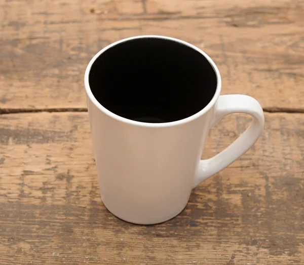Uma xícara vazia de café em uma mesa de madeira . — Fotografia de Stock