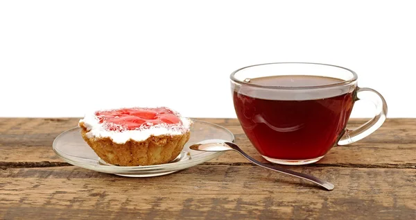 Fresh cupcakes and a glass cup tea on wooden table — Stock Photo, Image