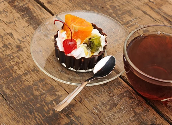 Delicious cake with fruit and a cup of tea — Stock Photo, Image