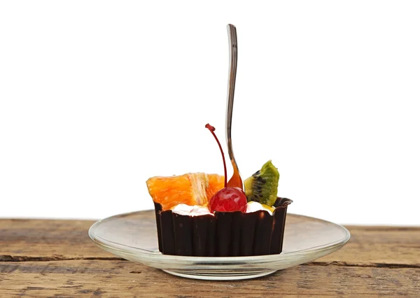 Шоколадний кекс з вишневим і тропічним фруктами на скляній тарілці — стокове фото