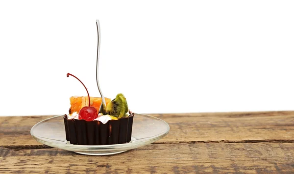 Schokoladen-Cupcake mit Kirsche und tropischen Früchten auf Glasschale — Stockfoto