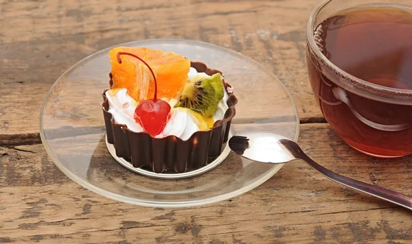 Délicieux gâteau aux fruits et une tasse de thé — Photo