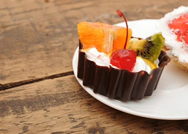 Frisch gebackener Cupcake auf dunklem Holzgrund — Stockfoto